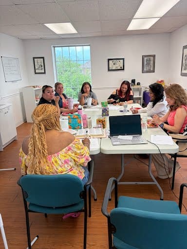 Integrantes de la comunidad reunidas alrededor de una mesa durante un taller de Beacon of Hope.