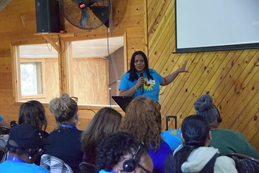 A facilitator speaking to attendees during a Beacon of Hope women-centered retreat workshop.